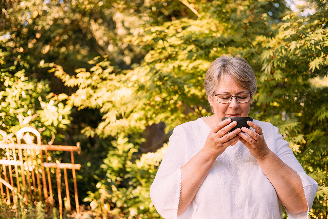 Frau trinkt Tee draußen in der Natur