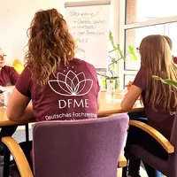 Das Team des DFME sitzt an einem Tisch und bespricht sich.
