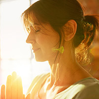 Eine Frau meditiert in der Sonne
